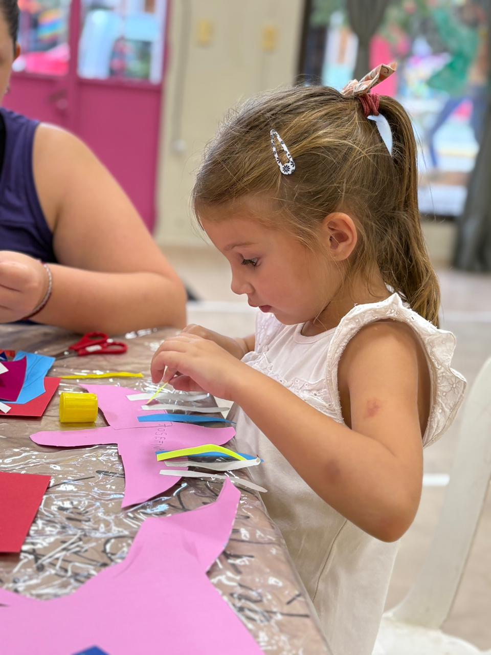 Taller de artes — niña con papeles de colores