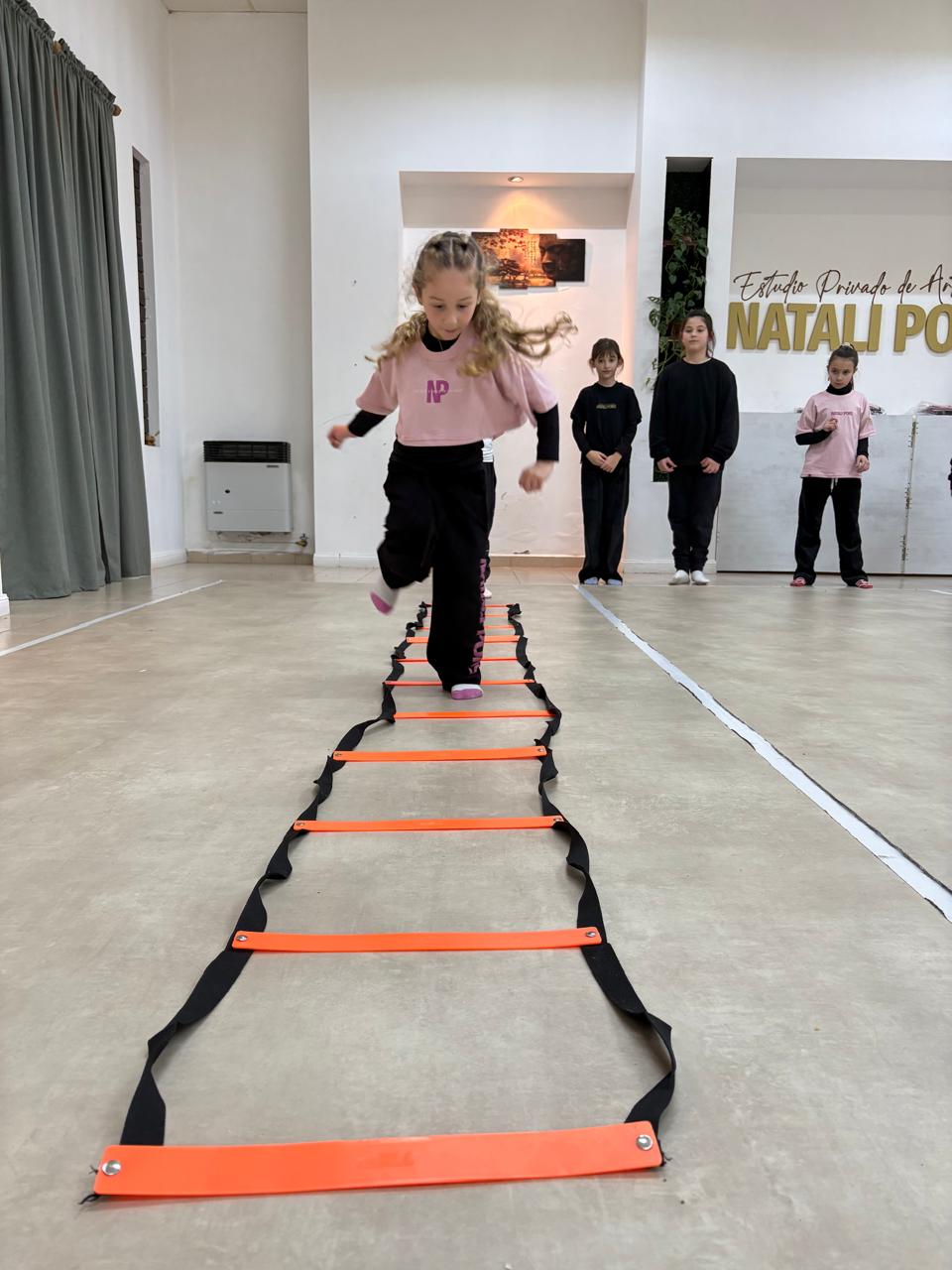 Niña entrenando con escalera de coordinación